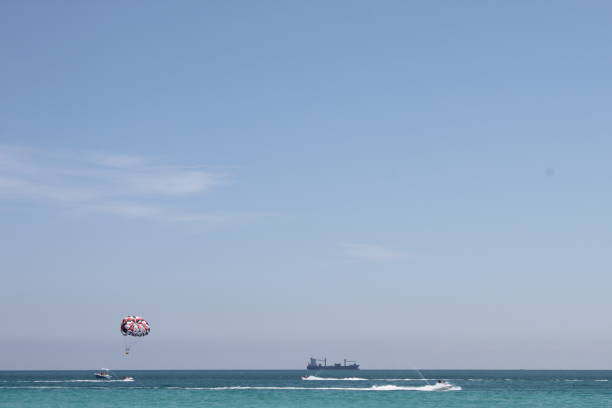 Miami Beach, Florida Cargo ship and parasailing in Miami Beach, Florida. miami parachuting stock pictures, royalty-free photos & images