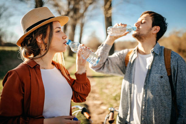 istock Couple relaxing in nature after walk with water 1213593740