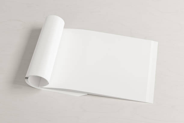 istock Blank magazine page. Workspace with folded magazine mock up on the desk. 1213598327