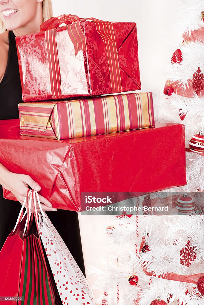 Donna sorridente con Natale presenta - Foto stock royalty-free di 20-24 anni