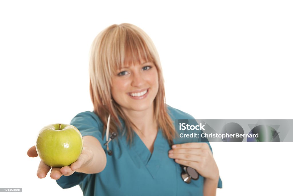 Souriant Infirmier tenant une pomme verte - Photo de Suivi des malades libre de droits