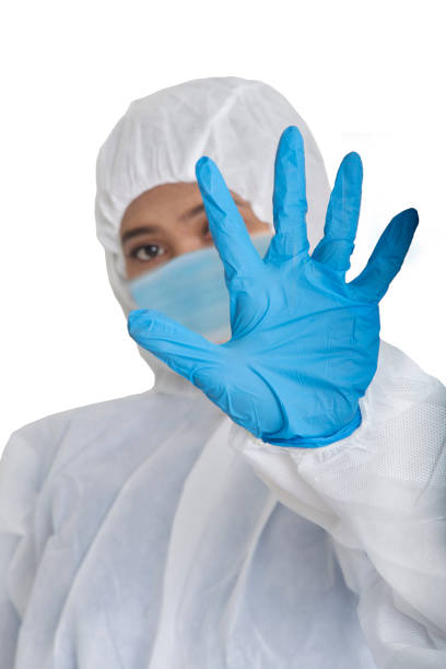 istock Female officer in protecive suit raise her hand as a sign to stop. 1213606353