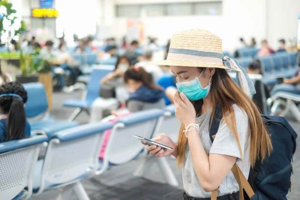 Covid-19 virus and Air pollution pm2.5 concept. Asian woman wearing mask for Virus and quarantined at airport terminal.Virus outbreak.Covid19 coronavirus and epidemic virus symptoms. stock photo