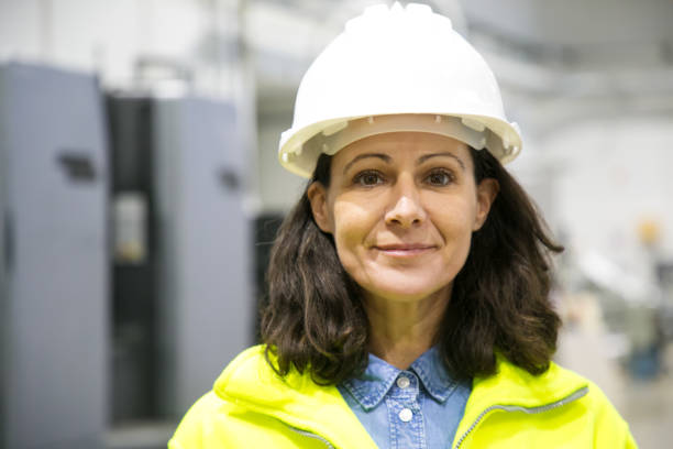 istock Smiling confident female industrial worker posing on plant floor 1213613324