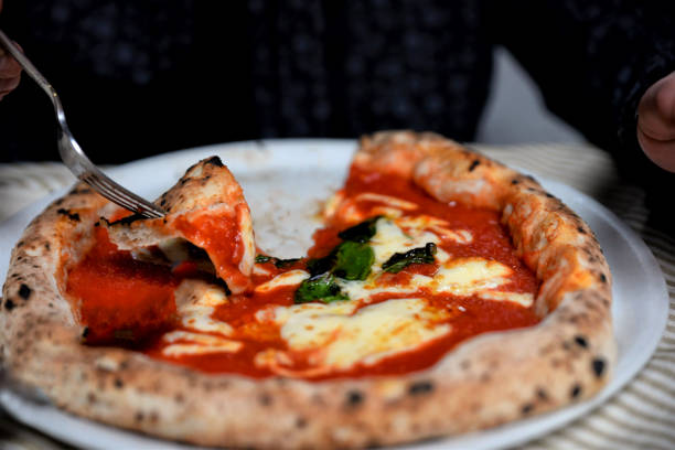 istock margarita pizza on plate and hand with fork 1213614065