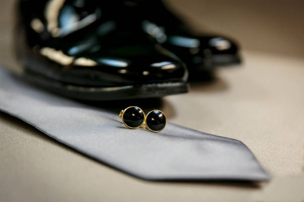 istock Wedding shoes, tie and tie clasp on a table 1213614849