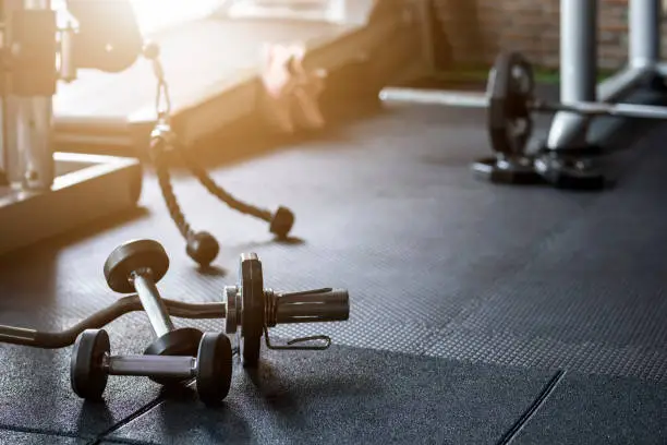 Photo of Gym background Fitness weight equipment on empty dark floor