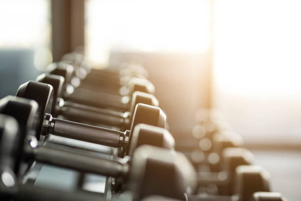 フィットネス機器ダンベルワークアウトのための重量とジムの背景 - gym weight bench exercising weights ストックフォトと画像