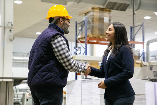 istock Smiling office manager shaking hands with factory worker 1213619628