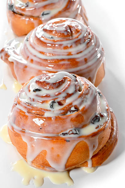 istock raisin snail buns close-up poured with cream on white background 1213621748