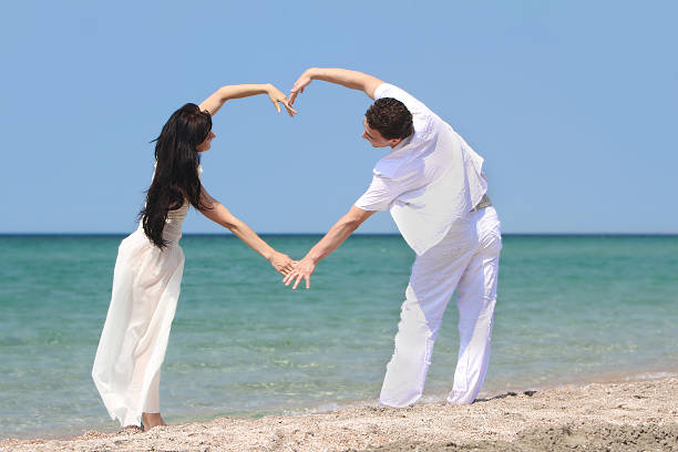 istock young couple making heart by arms on beach 121362205