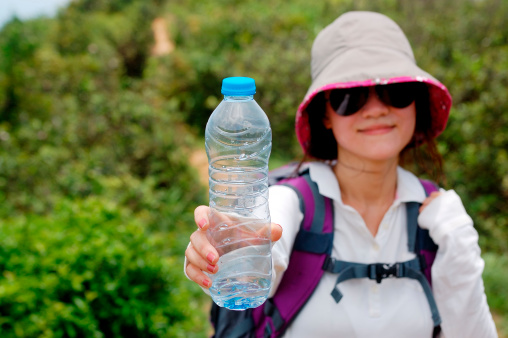 a hking young woman holding a bottle of water