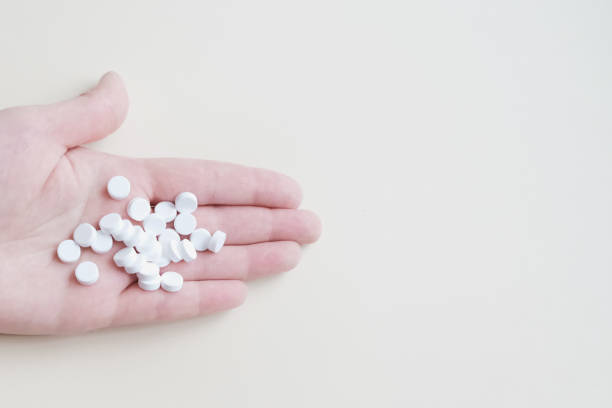 istock many white pills in the palm on a light background, medicine 1213622519