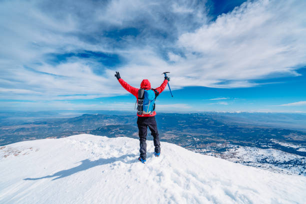 lo scalatore alpino di montagna tiene in mano l'ascia di ghiaccio e fa segno di pace sulla vetta della montagna d'alta quota in inverno - turkey extreme terrain snow nature foto e immagini stock