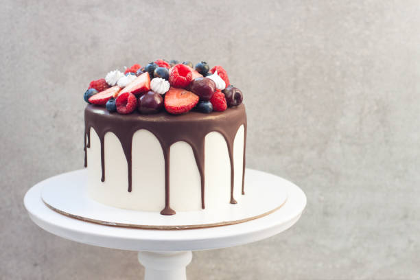 istock White cake with melted dark chocolate, fresh strawberries, blueberries, raspberries and cherries 1213624822