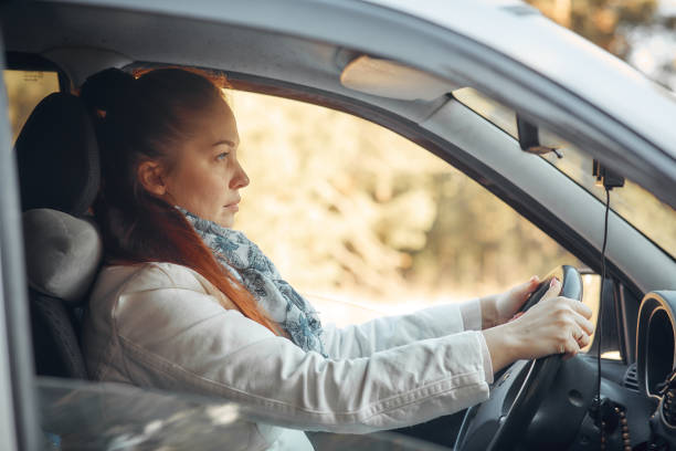 istock young beautiful woman driving a car. 1213629540
