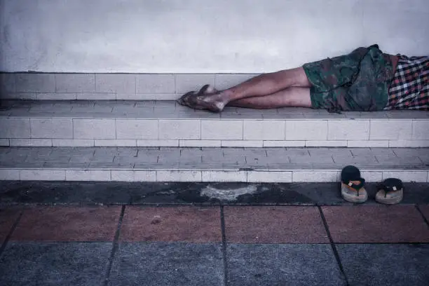 Photo of Homeless man dirty sleeps on the street