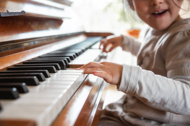 istock little girl playing piano 1213631204