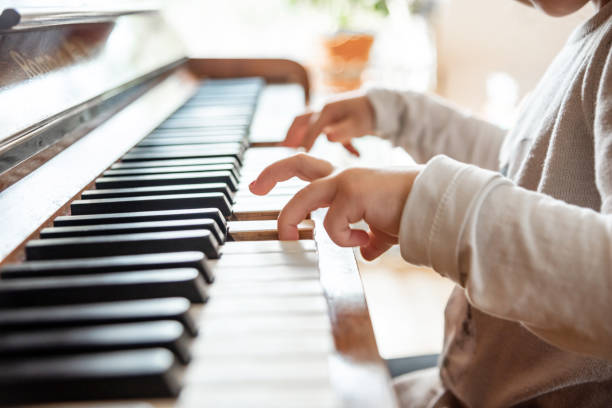 istock little girl playing piano 1213631255