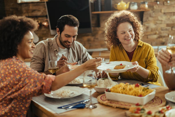 istock Young happy friends enjoying in lunch at dining table. 1213633292