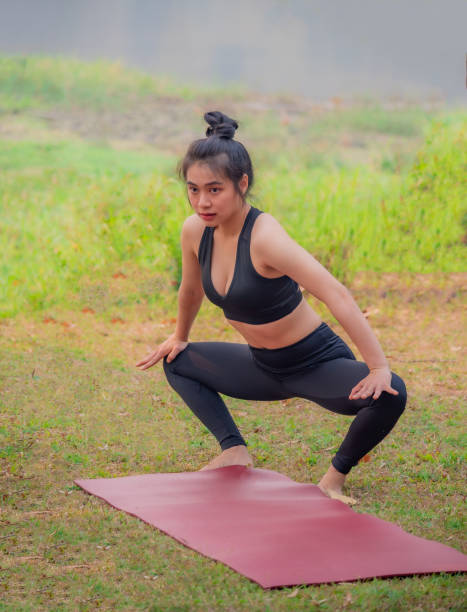 istock A beautiful woman practicing yoga in a lakeside garden. 1213636149
