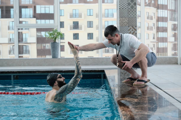 istock Coach congratulating swimmer with best lap time 1213638136