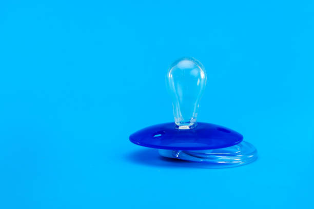 istock a pacifier babies made of transparent soft latex, plastic soother isolated on blue background with copy space. 1213640969