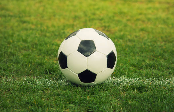 Classic soccer ball, typical black and white hexagon pattern, placed on the stadium turf. Traditional football ball on the green grass field of arena. Classic soccer ball, typical black and white hexagon pattern, placed on the stadium turf. Traditional football ball on the green grass field of arena. the black ball stock pictures, royalty-free photos & images
