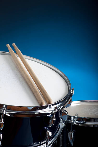 istock Close-up of a snare drum with two drumsticks and blue wall 121364338