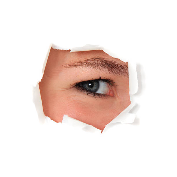 istock Female person looking through torn white paper hole 121364408