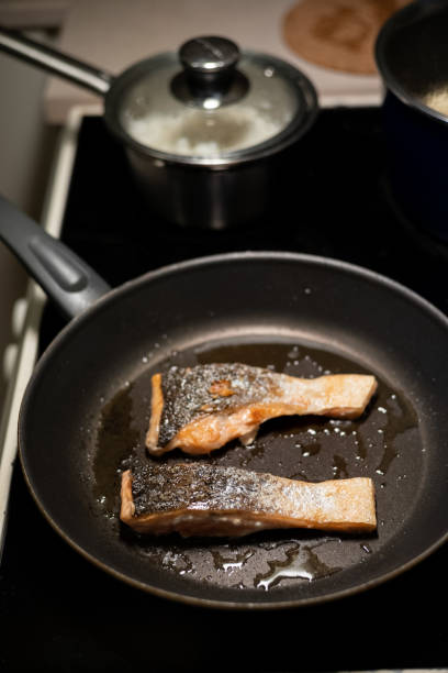 istock Pan searing fresh salmon fillet in kitchen 1213645588