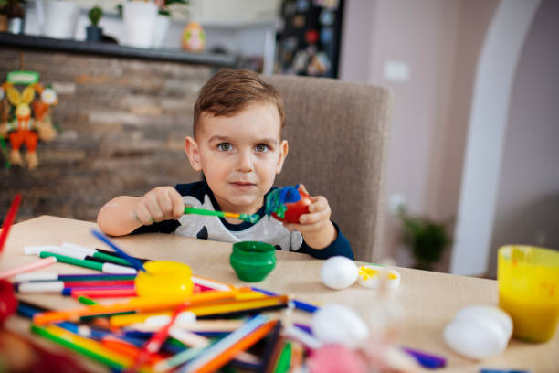 istock Little boy painting Easter eggs stock photo 1213646640