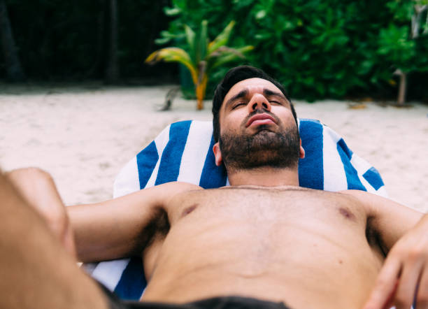 istock Young man sunbathing on a deckchair in nature 1213653697