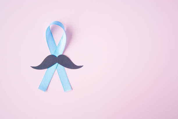istock Prostate Cancer Awareness, light Blue Ribbon with mustache on pink background for support people living and illness. Men Healthcare and World cancer day concept. Men carcinoma health symbol 1213653870