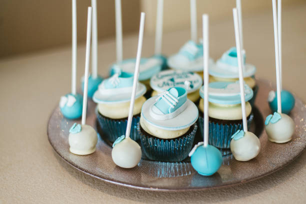 istock Cup cakes decorated with blue icing and sneakers and baby foot steps 1213656813