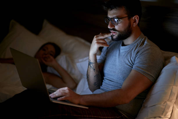 istock Modern Workaholic-Businessman lying on bed and working with laptop late at night. 1213656823