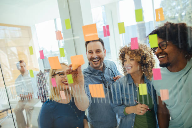 istock Business team brainstorming in front of glass wall with adhesive notes 1213656998