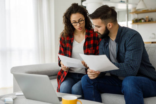 istock Young couple going through their paperwork together at home 1213658098
