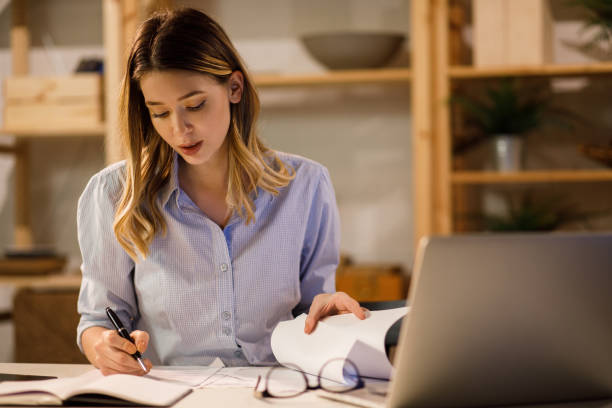 istock Young woman doing finances at home using laptop 1213658298