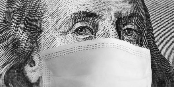 Protective mask on hundred dollar bill. Coronavirus 2019. Quarantine measures. World financial crisis in 2020. Coronavirus pandemic. Economic recession. Virus outbreak crisis. Medical mask on face