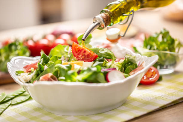 istock Bottle with olive oil pouring into salad 1213659929