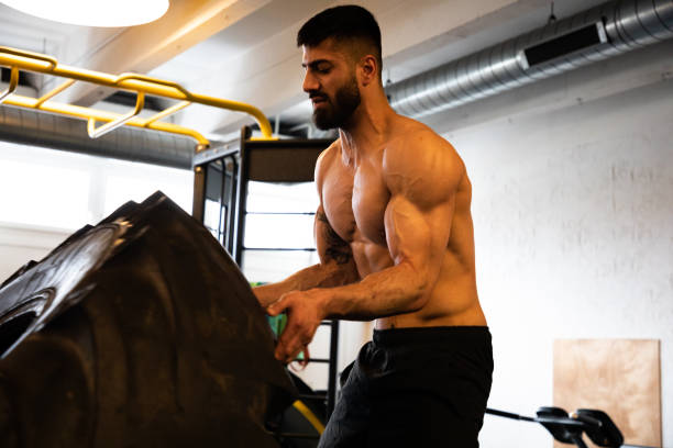タイヤリフト ボディービル エクササイズ 若い男の筋力トレーニング - body building weight training muscular build human muscle ストックフォトと画像
