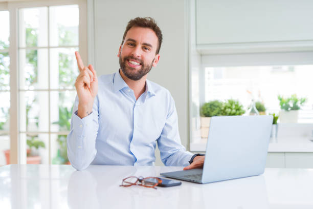 istock Handsome business man working using computer laptop very happy pointing with hand and finger to the side 1213664413