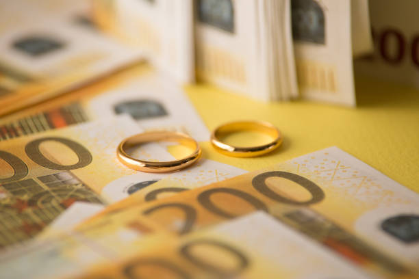 istock Golden wedding rings on banknotes background. Marriage of 1213664477