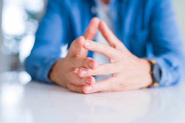 istock Close up of man hands with palms together over white table 1213664951