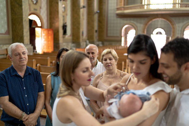 madre dando hijo a los padrinos en la celebración del bautismo - ahijado fotografías e imágenes de stock