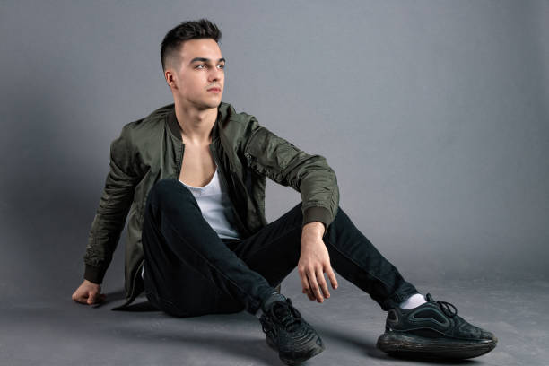 istock Young serious man posing in studio. Gray background 1213668275