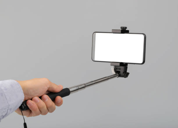 istock hand holds selfie stick with phone with screen 1213669716