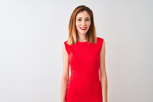 Redhead businesswoman wearing elegant red dress standing over isolated white background with a happy and cool smile on face. Lucky person.