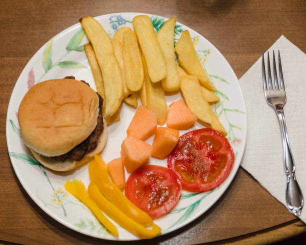 istock first spring dinner, burgers, fries, melon, tomatoes and peppers 1213671844